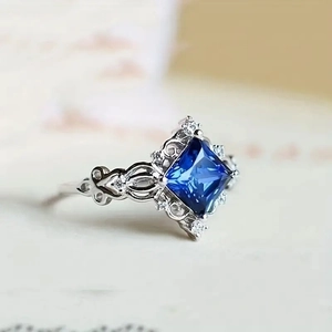 Macro shot of square blue gemstone ring with intricate vintage hollow carving details