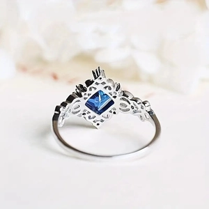Macro shot of silver ring with vintage filigree details and square blue gemstone inlay