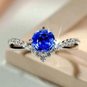 Macro view of blue zircon wedding ring with V-shaped pavé setting and silver band