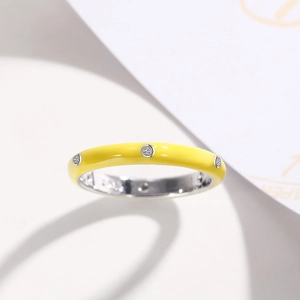Macro detail of yellow enamel ring with sparkling zircon stones and silver inner band