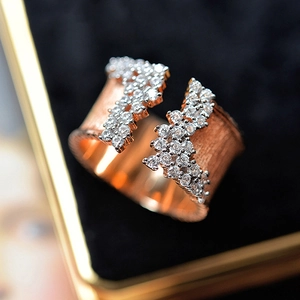 Close-up of luxury rose gold ring featuring brushed texture and paved white zircons