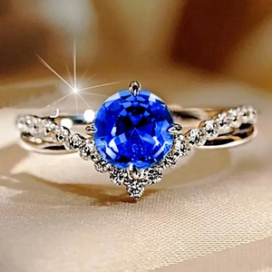 Elegant V-shaped silver ring featuring a large blue round zircon and pavé setting stones