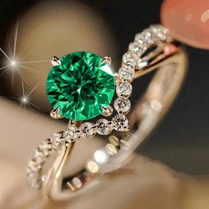 Macro shot of V-shaped rose gold ring with a round green zircon and pavé diamond detail