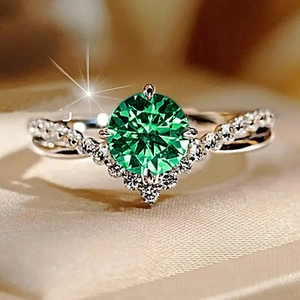 Macro detail of V-shaped green gemstone wedding ring with pavé diamonds and twisted band
