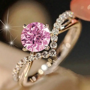 Macro shot of pink zircon ring with rose gold band and four-prong pavé setting