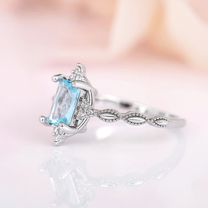 Elegant silver crown ring with light blue rectangular gem and white cubic zirconia