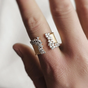 Macro detail of gold-plated open ring with brushed texture and pavé set cubic zirconia