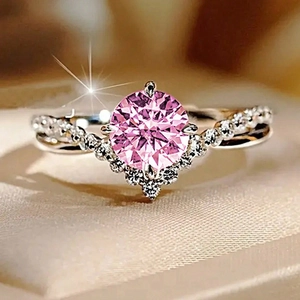 Macro detail of round pink gemstone ring with V-shaped pavé setting and silver band