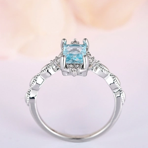 Macro view of a rectangular light blue gemstone set in a vintage crown style silver ring