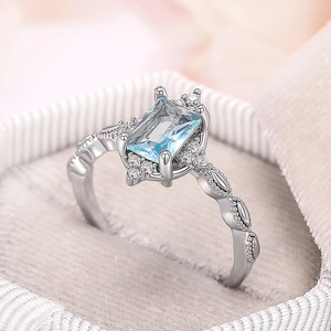 Elegant silver crown ring with rectangular light blue gemstone and leaf pattern