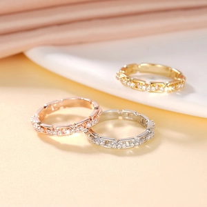 Makro-Detail von dreifarbigen Kettenringen in Gold, Roségold und Silber mit Mikrozirkonia