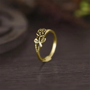 Macro detail of vintage gold 3D rose ring showing intricate petal texture and leaf design