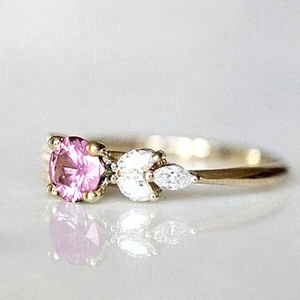 Détail d'une bague avec pierre rose ronde et cristaux marquise sur anneau doré