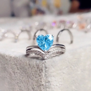 Macro shot of silver heart ring with aquamarine gemstone and pavé V-shaped band
