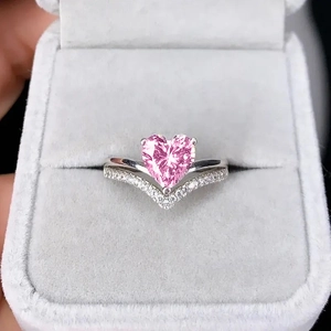 Detailed macro view of a pink heart gemstone ring with a V-shaped pavé diamond band