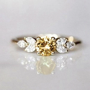 Détail de bague en argent élégante avec pierre jaune centrale et accents de diamants marquise