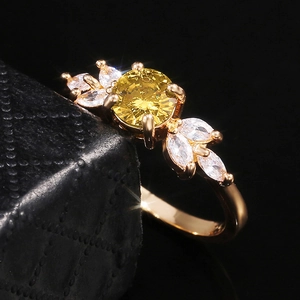 Vue macro d'une bague en or rose avec pierre jaune et pétales en diamants marquise