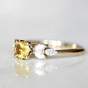 Vue macro détaillée d'une bague avec pierre jaune et pierres marquises sur anneau doré