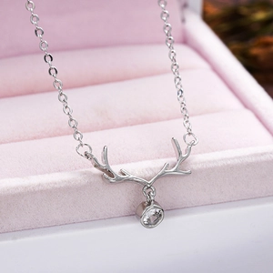 Macro shot of silver reindeer antler pendant with crystal in pink velvet jewelry box