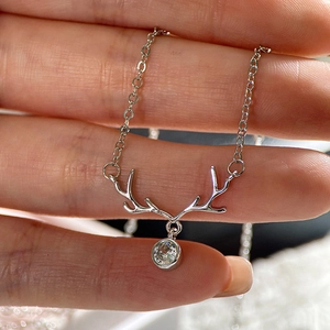 Detailed view of silver elk antler pendant necklace with a round clear sparkling stone