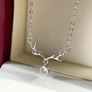 Macro shot of silver reindeer antler necklace with zircon in a red gift box