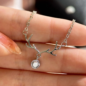Macro shot of silver reindeer antler pendant with sparkling zircon on fine O-ring chain