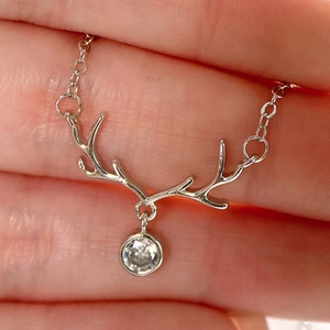 Detailed view of silver reindeer antler necklace with sparkling crystal pendant
