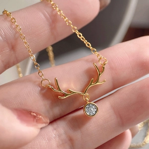 Macro shot of gold reindeer antler pendant necklace with a brilliant round white stone