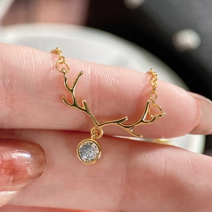 Close-up of golden reindeer antler necklace with a round sparkling zircon stone