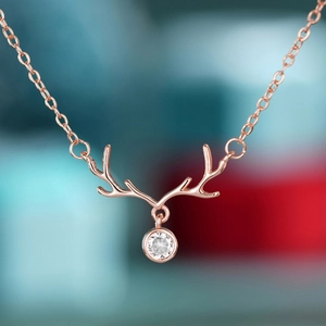Macro view of rose gold reindeer antler necklace with a sparkling round zircon pendant