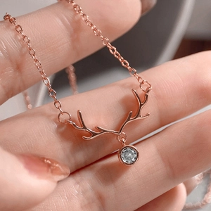 Close-up of rose gold elk antler necklace featuring a sparkling round zircon stone