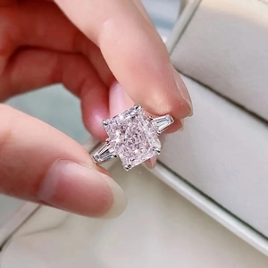 Detailed view of radiant cut pink zircon ring with side step-cut white diamonds