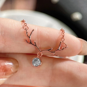 Close-up of rose gold elk antler necklace featuring a sparkling round zircon pendant