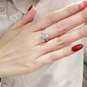 Close-up of a radiant cut pink zircon ring with side stones on a woman's finger