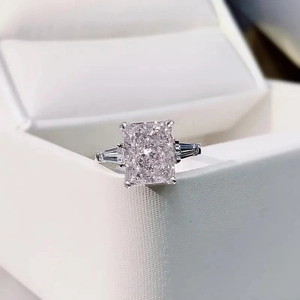 Macro shot of a radiant cut square stone ring with baguette side diamonds on a jewelry box