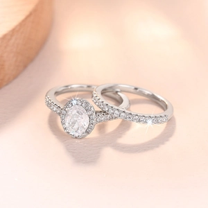 Makroaufnahme von silbernem Ring-Set mit ovalem Hauptstein auf warmem Hintergrund