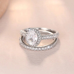 Nahaufnahme eines Ringsets mit ovalem Schmuckstein, Halo-Design und passendem Vorsteckring