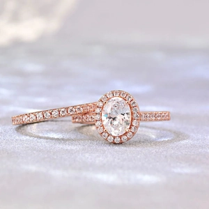 Detail eines Roségold-Ring-Sets mit ovalem Schliff, Halo und funkelnden Pavé-Diamanten