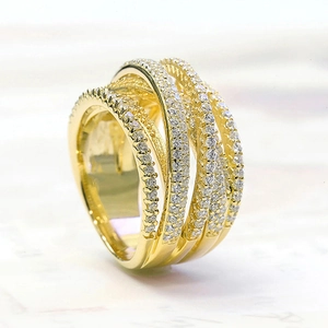 Vue détaillée d'une bague dorée multicouche croisée avec des pierres de zircone micro-pavées