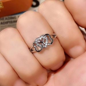 Close-up of interlocking silver double heart ring set with sparkling white zircon