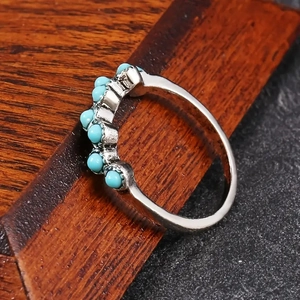 Vue macro d'une bague minimaliste en argent sertie de cinq pierres précieuses bleu ciel