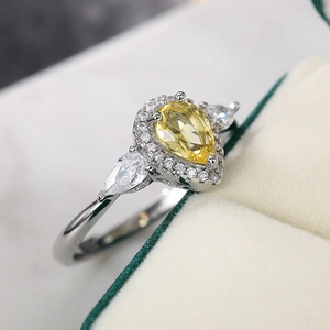 Dettaglio macro dell'anello con zircone giallo a goccia e montatura in argento