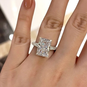 Gros plan d'une bague zircon taille radiant avec pavé sur la main d'un modèle