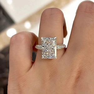Bague en zircone étincelante à coupe radiante avec anneau pavé sur la main