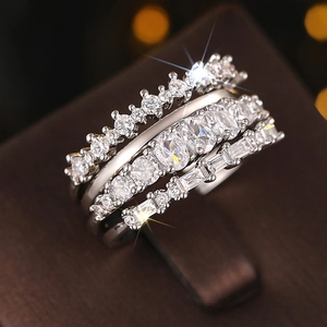 Detail of silver rings set with cubic zirconia on brown leather jewelry display