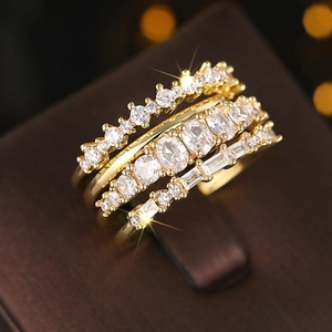 Macro shot of gold-plated multi-row rings featuring round and emerald cut zircons