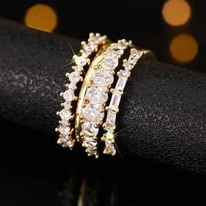 Macro detail of luxury gold stacked ring set with oval and emerald cut cubic zirconia