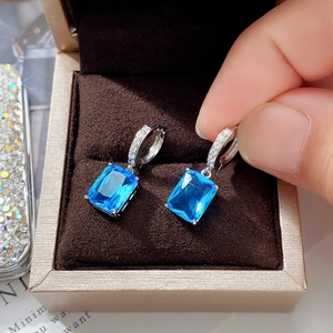 Detail of emerald cut sea blue zircon earrings with pavé setting in a jewelry box