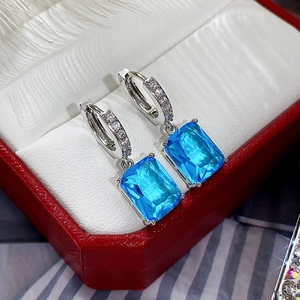 Detail of silver drop earrings featuring large rectangular sky blue zircon stones