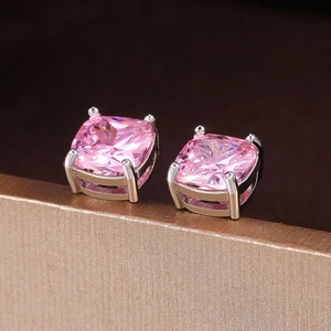 Nahaufnahme von quadratischen rosa Zirkon-Ohrringen mit silberner Vier-Klauen-Fassung